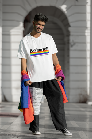 Man wearing the Be Yourself graphic tee with a rainbow pride flag.