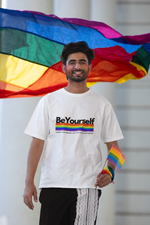 Man wearing the Be Yourself graphic tee with a rainbow pride flag.