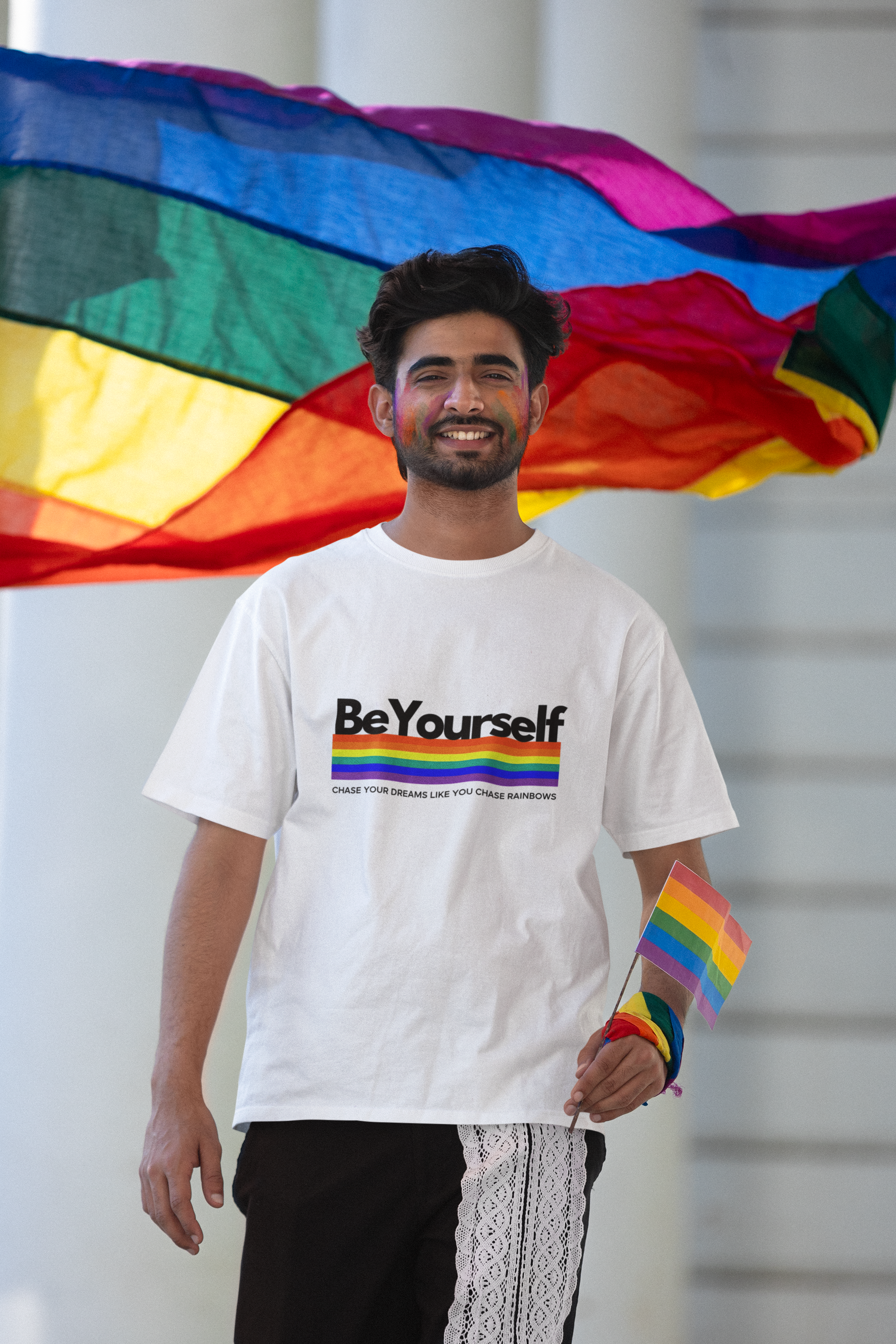 Man wearing the Be Yourself graphic tee with a rainbow pride flag.