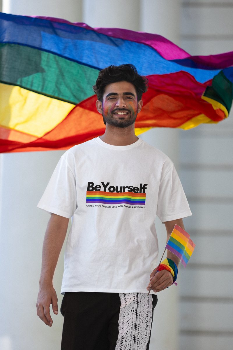 Man wearing the Be Yourself graphic tee with a rainbow pride flag.