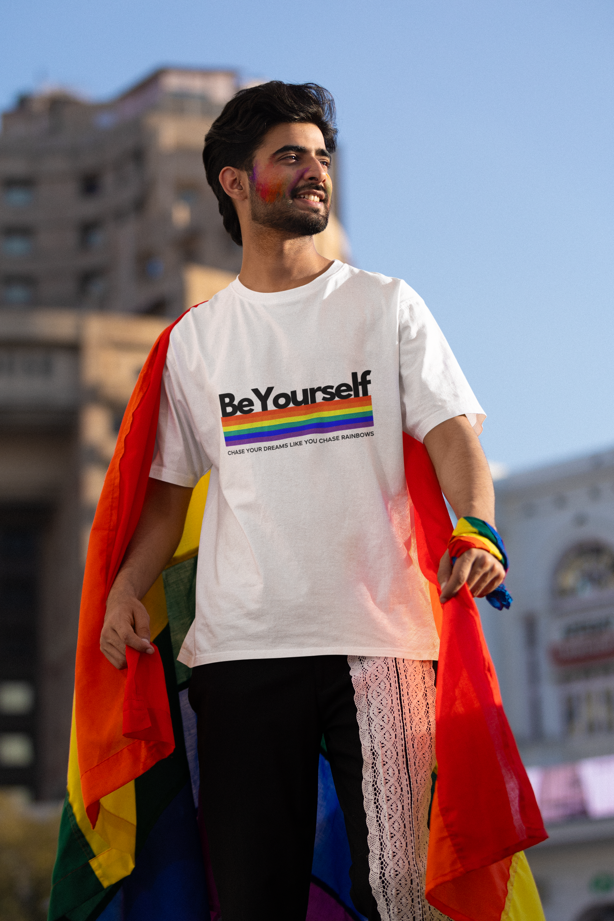 Man wearing the Be Yourself graphic tee with a rainbow pride flag.


